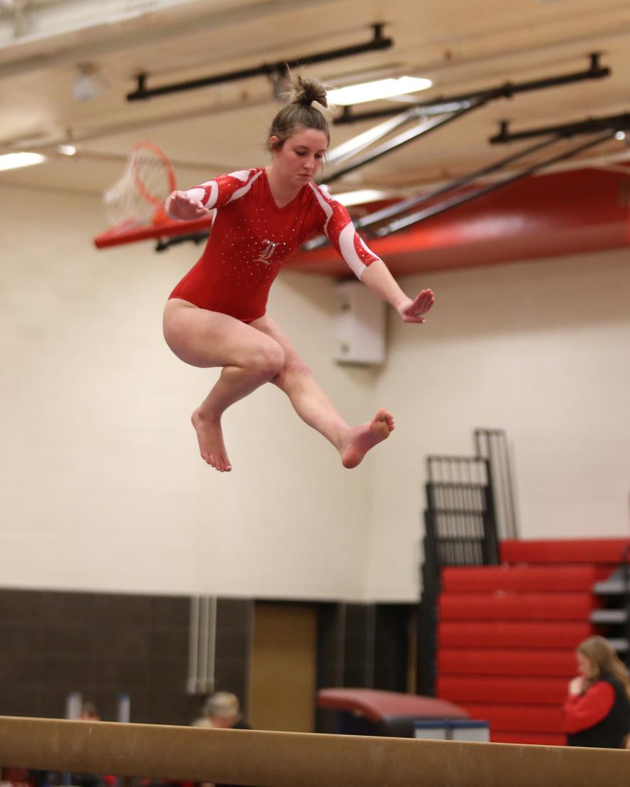 LHS junior Kendra Thorson leaps above the beam to perform one of the required skills in her routine. The Cardinals beat Redwood Valley 130.825 to 130.700 in the team competition. Thorson scored a 7.3500 on the beam.