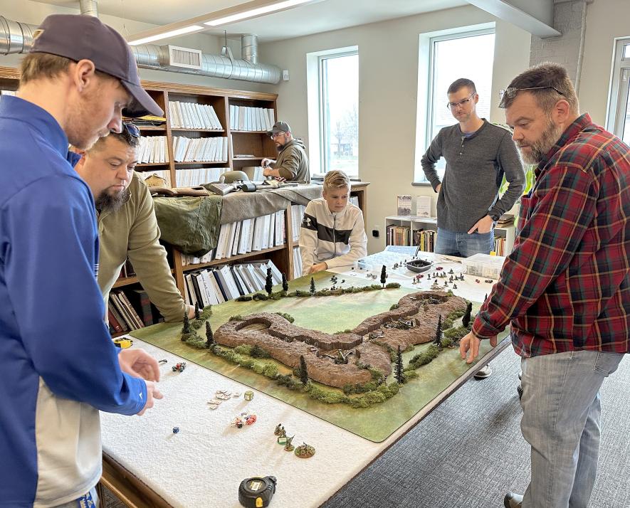 Miniature wargames at the History Center Saturday recreated the World War II Battle of Brecourt. Pictured are (clockwise from lower left) Dan Swoboda, Andrew Blank, (in back Aaron Blank), James and Tom Eggebrecht and Mike Westerbur. Lori Sorenson/Rock County Star Herald Photo