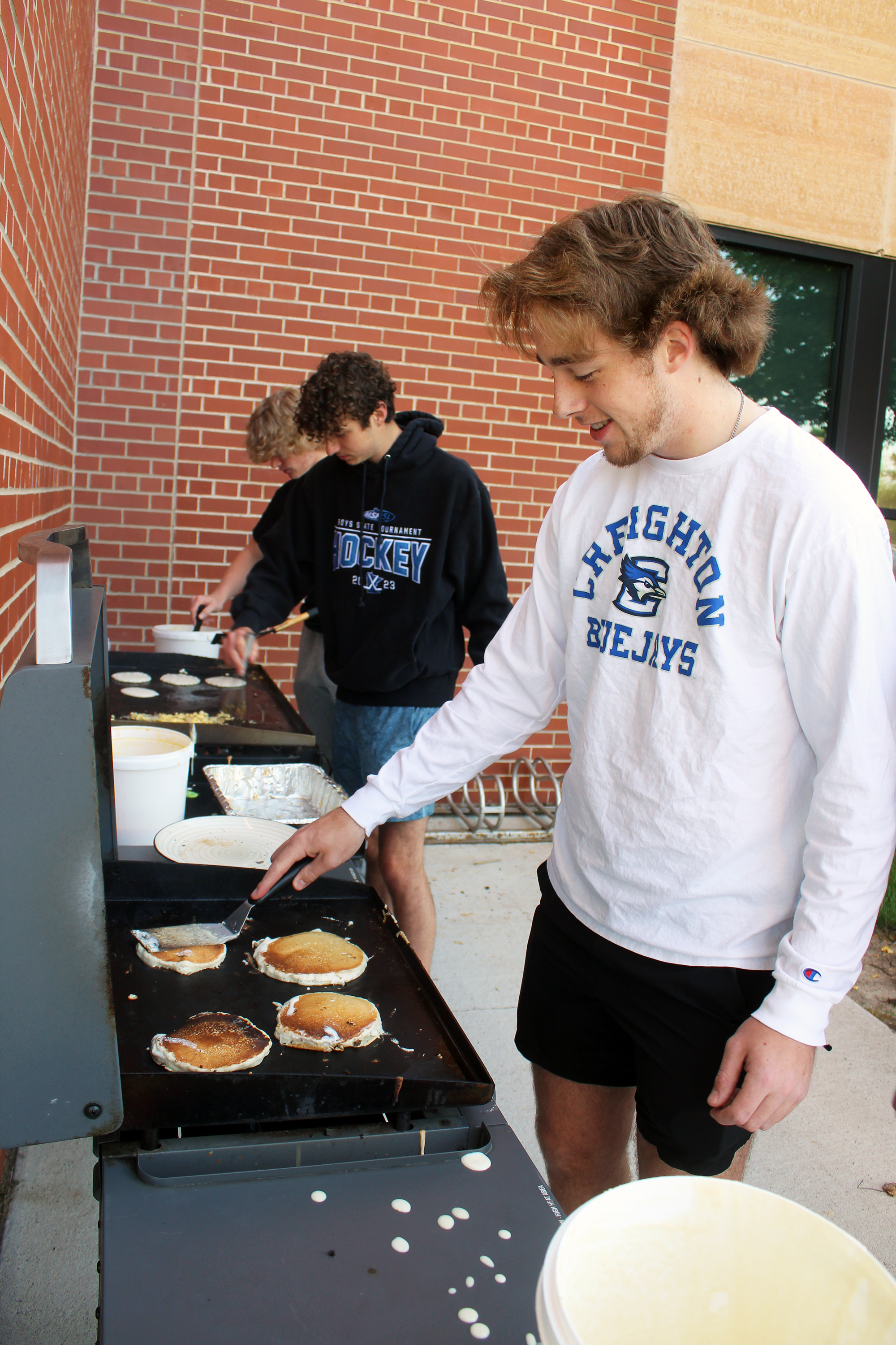 Luverne High School student council president Patrick Kroski grills pancakes with fellow seniors Tyler Arends (center) preparing scrambled eggs and Elliot Domagala also grilling pancakes. Mavis Fodness/Rock County Star Herald Photo