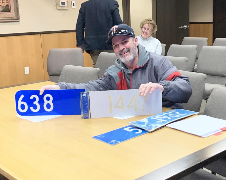 County Engineer Mark Sehr holds two E911 rural signs showing the readability difference between a new sign (left) and a sign installed in 2003 (right). Commissioners approved replacing all the weathered address signs in the county this year. Mavis Fodness/Rock County Star Herald Photo