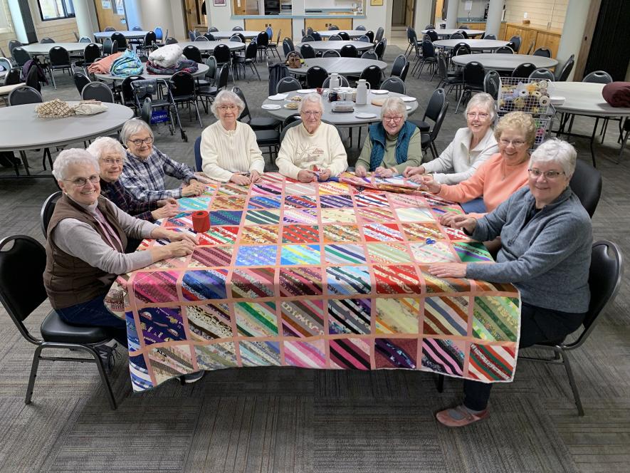 Grace Quilters gathered Thursday morning, Jan. 23 to tie together the quilt made from scraps to be sent to Guatemala in June during a mission trip. Three of the “scrappy” quilts were sent to California to be given to residents whose homes and belongings were lost to recent wildfires. Quilt members include (from left) Dianna Spath, Arlene Bendix, Karen Menage, Linda Renken, Mary Akkerman, Carol Green, Barb Oldre, Carol Richters and Vicky Henderson. Mavis Fodness/Rock County Star Herald Photo
