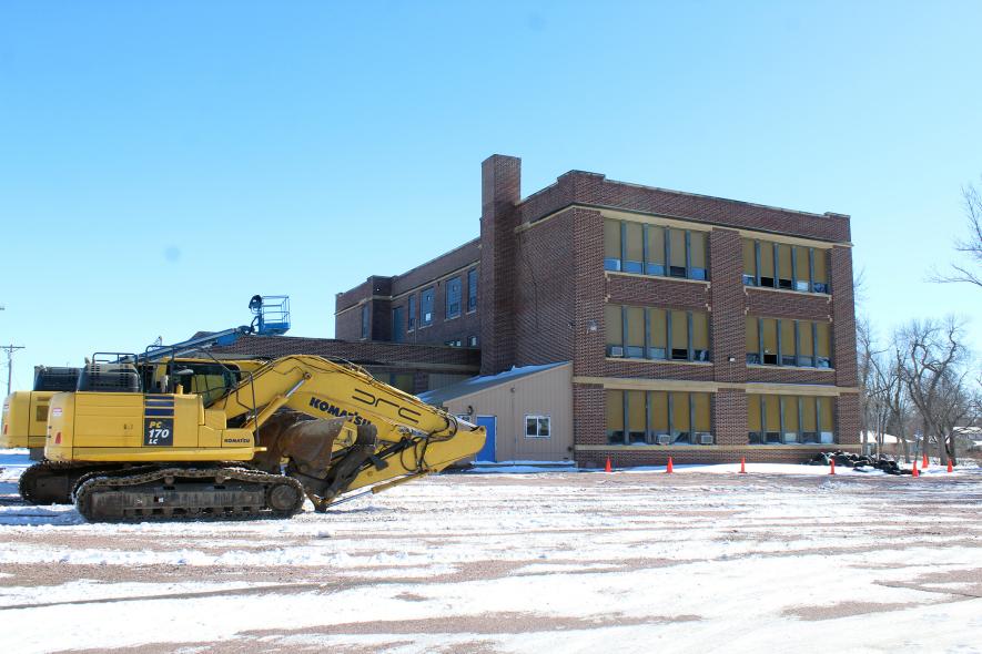 Equipment from DRC Inc. of Litchfield is parked at the former Hills-Beaver Creek High School in Hills in preparation for tearing down the more than 100-year-old structure. Once all the asbestos is removed (including the windows), demolition may begin as soon as next week. Mavis Fodness/Rock County Star Herald Photo