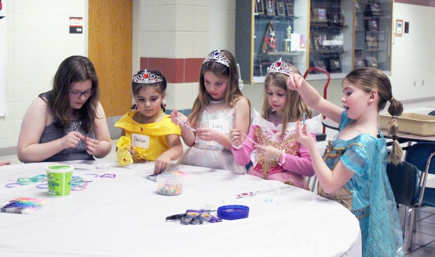 Mavis Fodness photo. Princess Gala 2025 Stringing bead bracelets in the Luverne Elementary Commons Feb. 25 are (from left) FCCLA member Charlotte Bierman and princesses Penelope Salinas, Lucy Almond, Madilyn Lysne and Gabby Lynch.