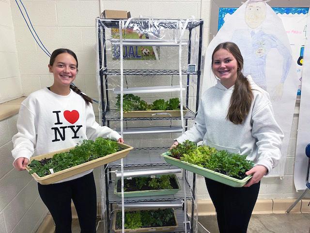 Luverne Middle-High School eighth-graders Sophia Nolz (left) and Mallory Edstrom hold trays of plants grown in the school’s new classroom greenhouse received through a $500 donation to the school’s ag department from the family of the late Al Willers. Submitted Photo