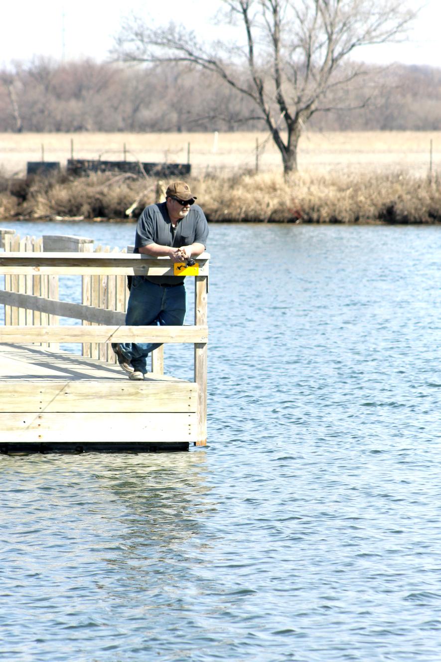 Bryce Schomacker of Luverne enjoys fishing from the dock into open water Monday afternoon at Schoeneman Park south of Luverne. Typically, anglers are considering taking their ice huts off area lakes as the spring thaw comes near. Mavis Fodness/Rock County Star Herald Photo