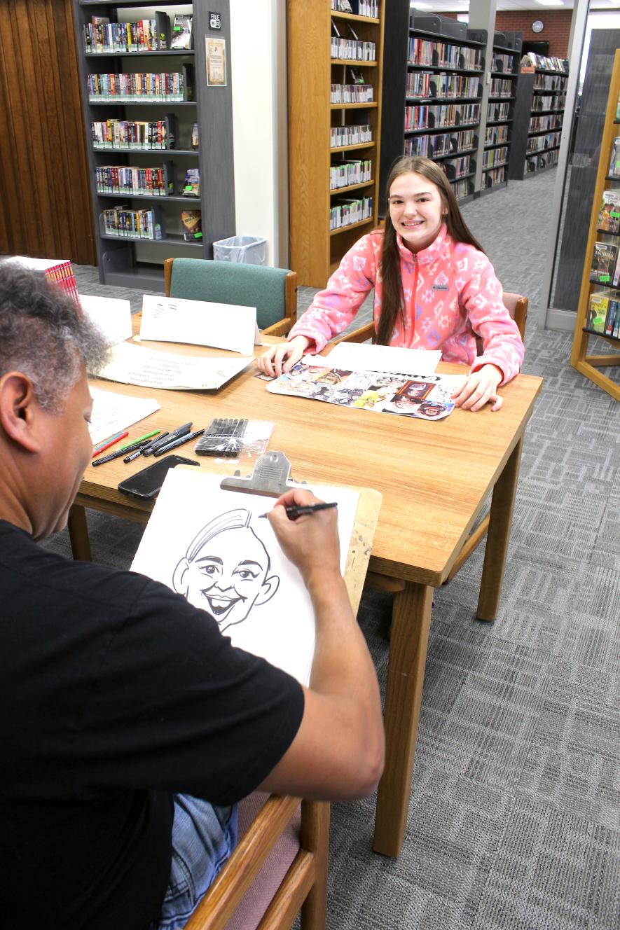 Zakada Bradley of Luverne has her caricature drawn by Hector Curriel Monday morning. Mavis Fodness/Rock County Star Herald