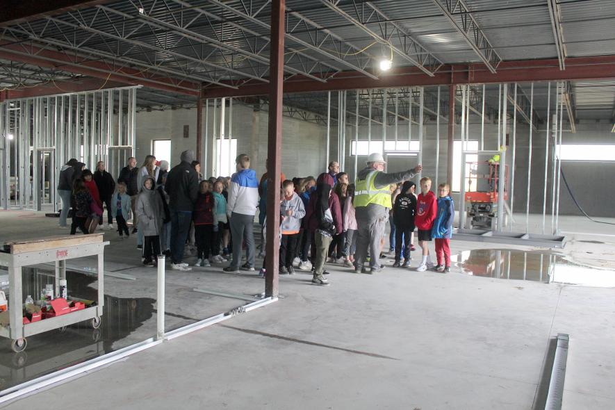 RA Morton Construction Manager Michael Beach (in hard hat) points out the opening that will become glass doors to the proposed bus pickup area on the school’s north side. Mavis Fodness/Rock County Star Herald Photo