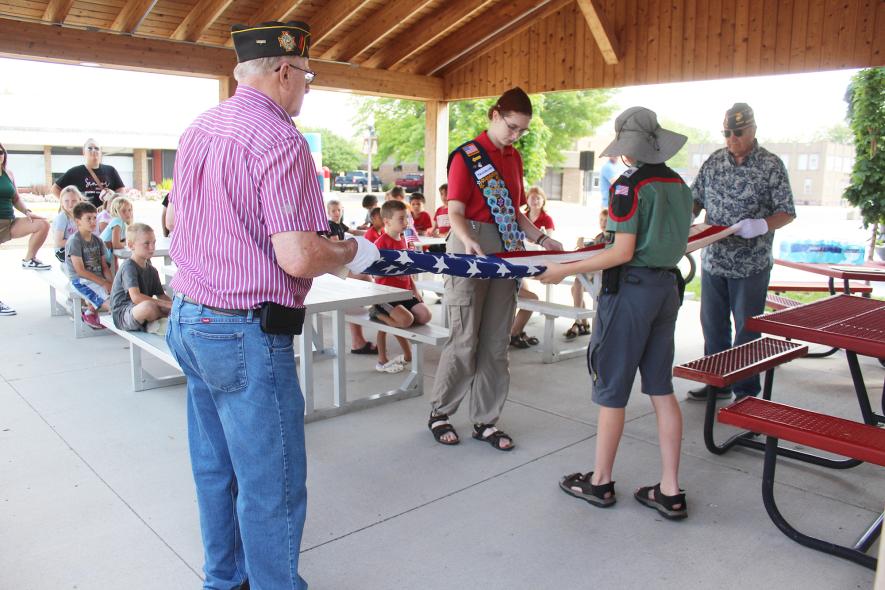 Demonstrating how to properly fold a flag Friday morning at the Plaza on Main in Luverne are (from left) Jerry Hoff, Naarah Fick, Samuel Fick and Terrie Gulden. Mavis Fodness/Rock County Star Herald Photo