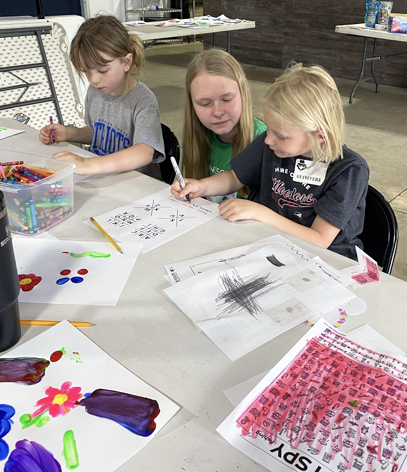 Summer Extension intern Danette Leenderts (center) shows Hailey Spykerboer (left) and Guinevere Carlson how to code using a PigPen key. Submitted Photo