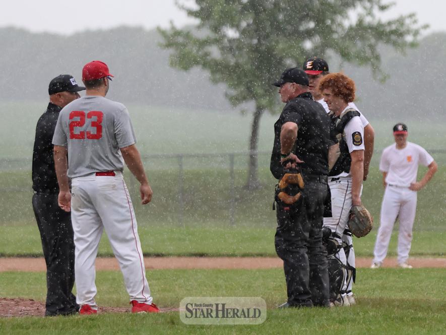 Coaches and umpires discuss weather conditions in Luverne Thursday, June 27. The Senior Legion game between Luverne and Edgerton was called off after one inning due to rain.