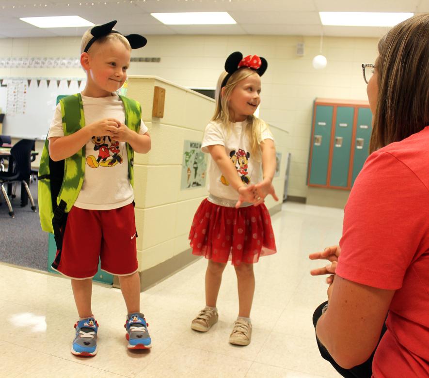 Lucah (left) and Laina Barron greet kindergarten teacher Brooke Van Essen as the twins search for their cubby spaces and desks during the elementary open house.Rock County Star Herald Photo/Mavis Fodness