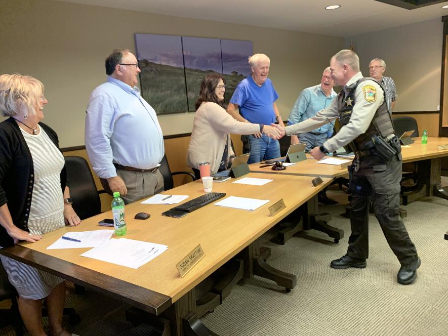 Derek Werner (far right) shares a laugh as he shakes the hands of commissioners (from right) Stan Williamson, Greg Burger, Gary Overgaard and Sherri Thompson along with county administrator Kyle Oldre and assistant administrator Susan Skattum. Mavis Fodness/Rock County Star Herald Photo