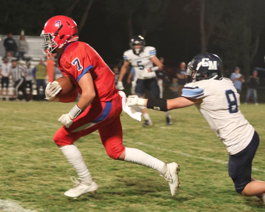 Junior Beau Bakken breaks through multiple Cougar defenders on his way to the end zone Friday, Sept. 15, in Hills. Bakken posted 119 total rushing yards in the Patriots’ 40-6 win.