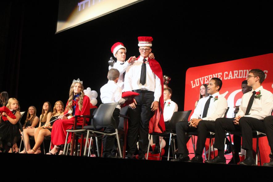 Placing the robe on newly crowned LHS Homecoming King Keaton Ahrendt (standing, right) is last year’s homecoming king, Zach Terrio. Mavis Fodness/Rock County Star Herald Photo