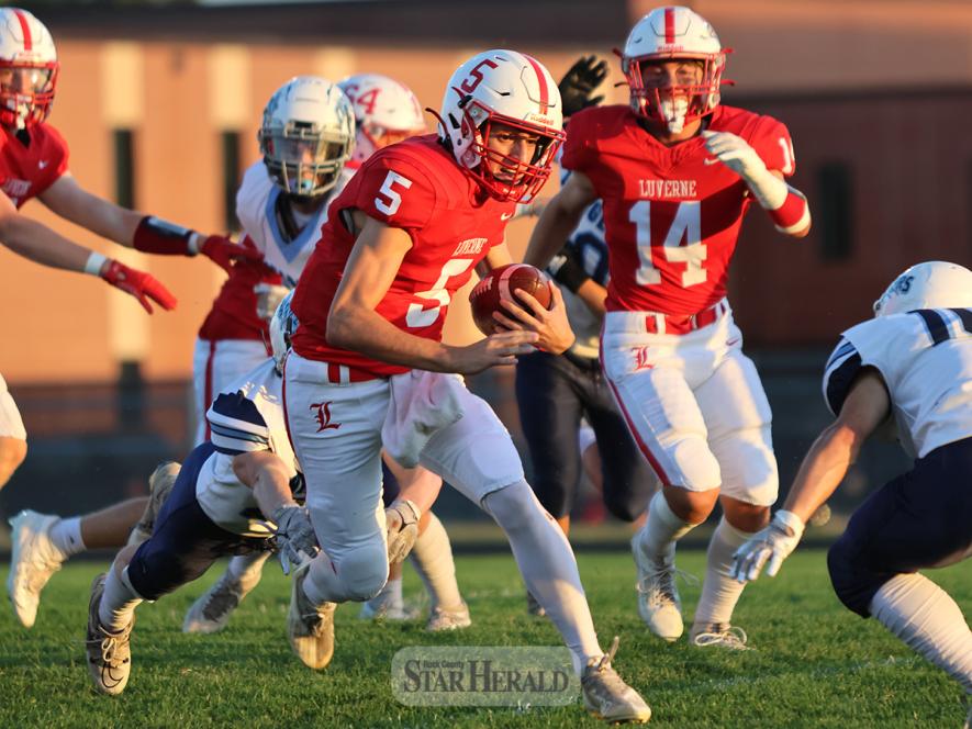 LHS senior quarterback Carter Sehr looks to make a cut against a Minnesota Valley Lutheran defenseman as he heads up the field Friday, Sept. 20, in Luverne. The Cardinals won the game 35-0 to improve to 4-0 for the season.