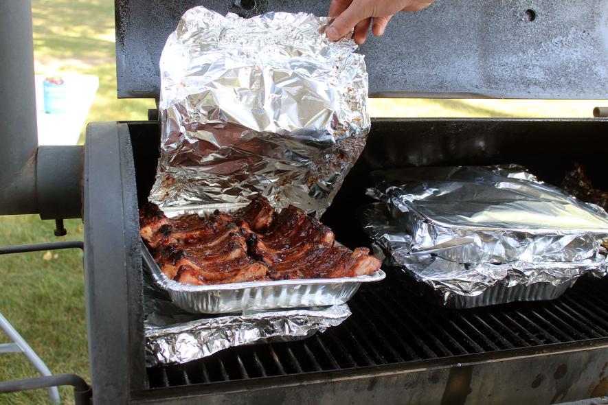 Lance Larson keeps the ribs he prepared for the Smokefest competition warm. The public was able to sample ribs prepared by all 18 entrants in the event in Hills Saturday afternoon. Mavis Fodness/Rock County Star Herald Photo