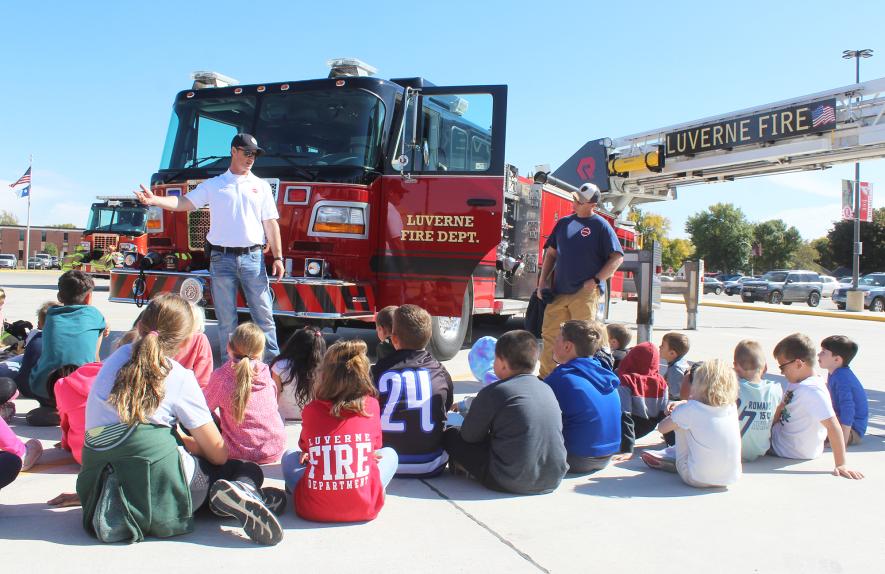 Luverne Fire Chief Dave Van Batavia (center) explains to a group of Luverne first- and fourth-graders the importance of closing bedroom doors while sleeping. Capt. Eric Lammert is pictured at far right.Mavis Fodness/Rock County Star Herald Photo