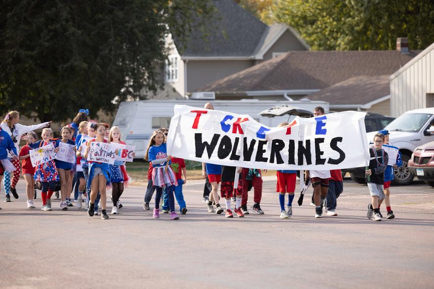 H-BC Elementary students brought a large banner, “Tackle the Wolverines,” and held smaller placards to encourage a football win on their walk in the Homecoming parade. Samantha McGaffee/Rock County Star Herald Photo