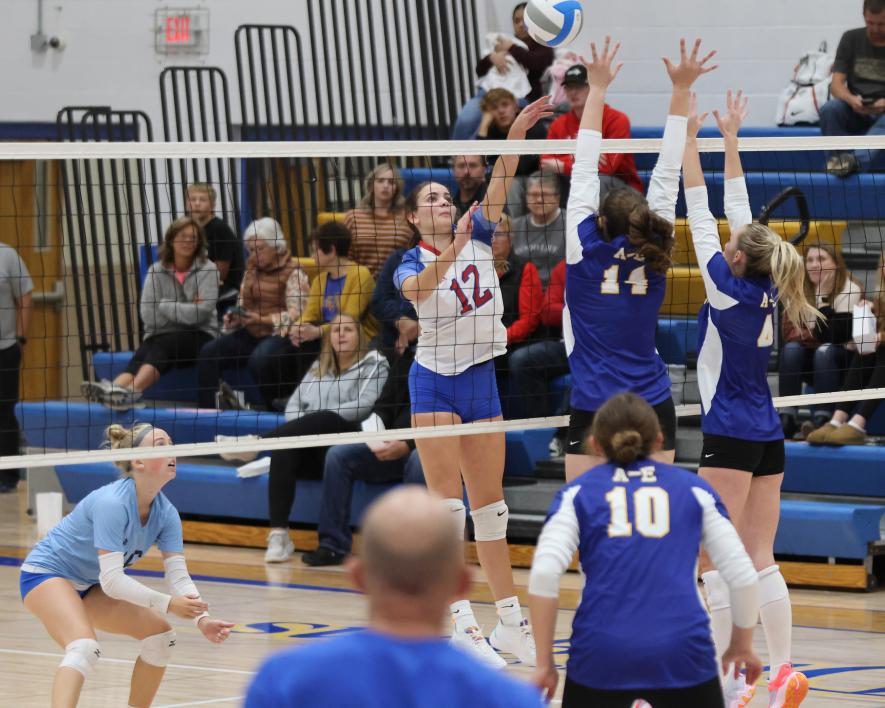 Freshman Olivia Deelstra lifts the ball over two Adrian blockers Tuesday, Oct. 10. Deelstra had six kills against the Dragons. The Patriots fell three sets to one on the road.