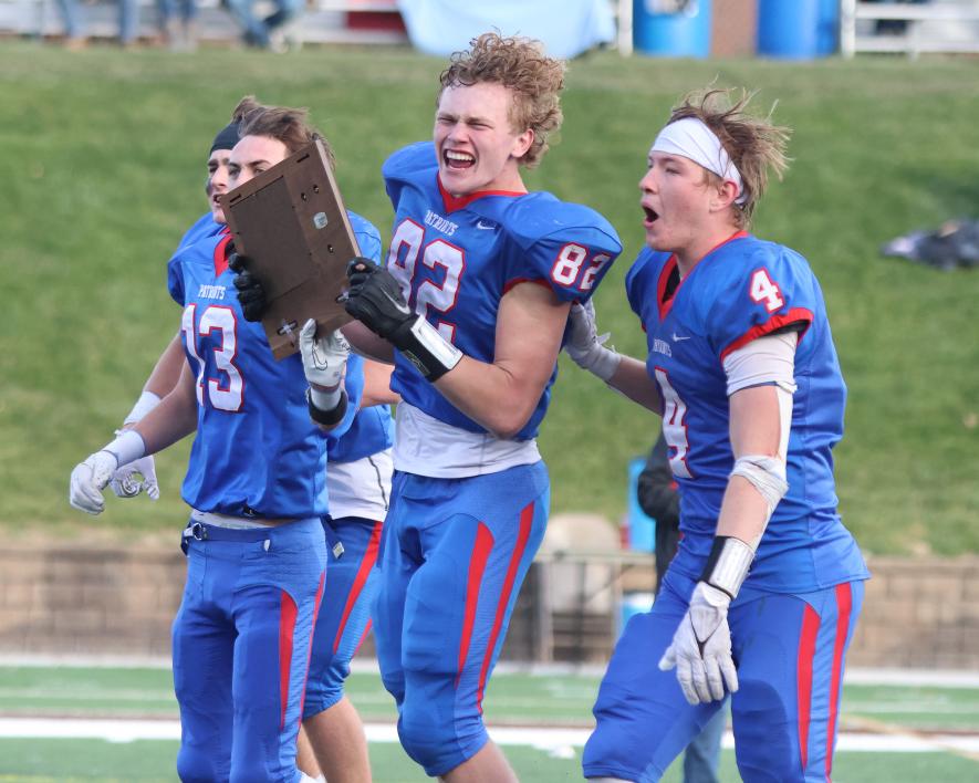 H-BC football team captain senior Riley Tatge (No. 82) hold the section championship trophy with fellow captains   junior Sawyer Bosch (from left, hidden), senior Cooper Gehrke (No. 13), and junior Beau Bakken (No. 4). 