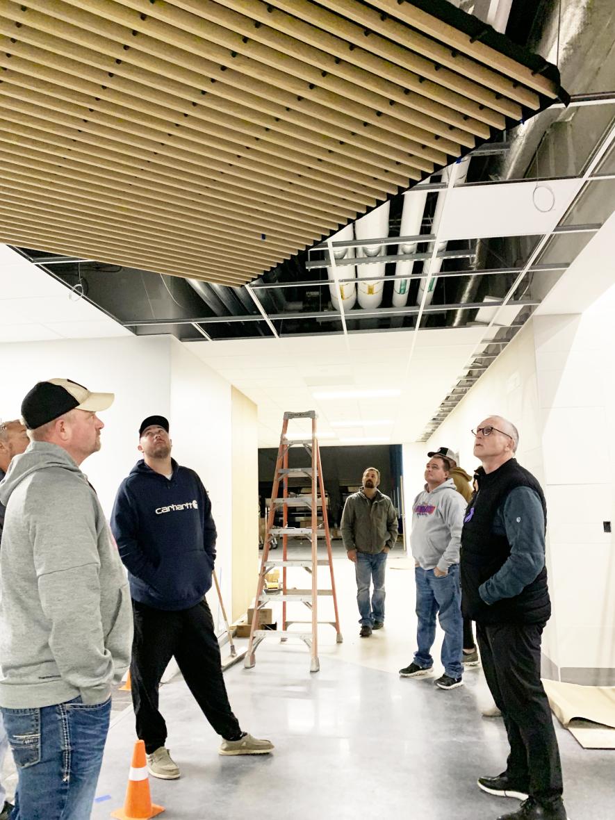 Hills-Beaver Creek school officials (from left) Tim Bosch, Arlyn Gehrke (hidden), Travis Helgeson, Ethan Rozeboom, Eric Uittenbogaard (hidden), Chris Harnack and Superintendent Todd Holthaus inspect the ceiling with its sound-buffering features at the new elementary school Monday night, two days before the facility will undergo the necessary state inspections for an occupancy permit. Mavis Fodness/Rock County Star Herald Photo