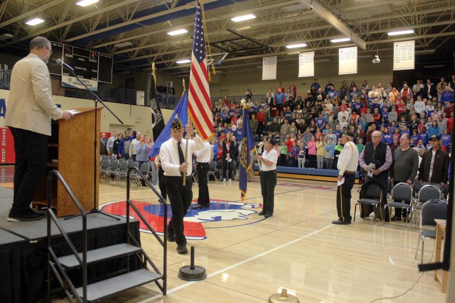 Hills American Legion Post 399 member Jesse Gaugler places the American flag during the posting of colors to open the Veterans Day program. Mavis Fodness/Rock County Star Herald Photo