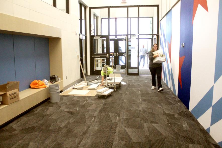 H-BC Elementary paraprofessional Julie Shamatt carries materials into the new Hills-Beaver Creek Elementary school in Beaver Creek Monday morning amid construction still taking place in the school. Classes in the new facility begin Monday, Dec. 1. Mavis Fodness/Rock County Star Herald Photo
