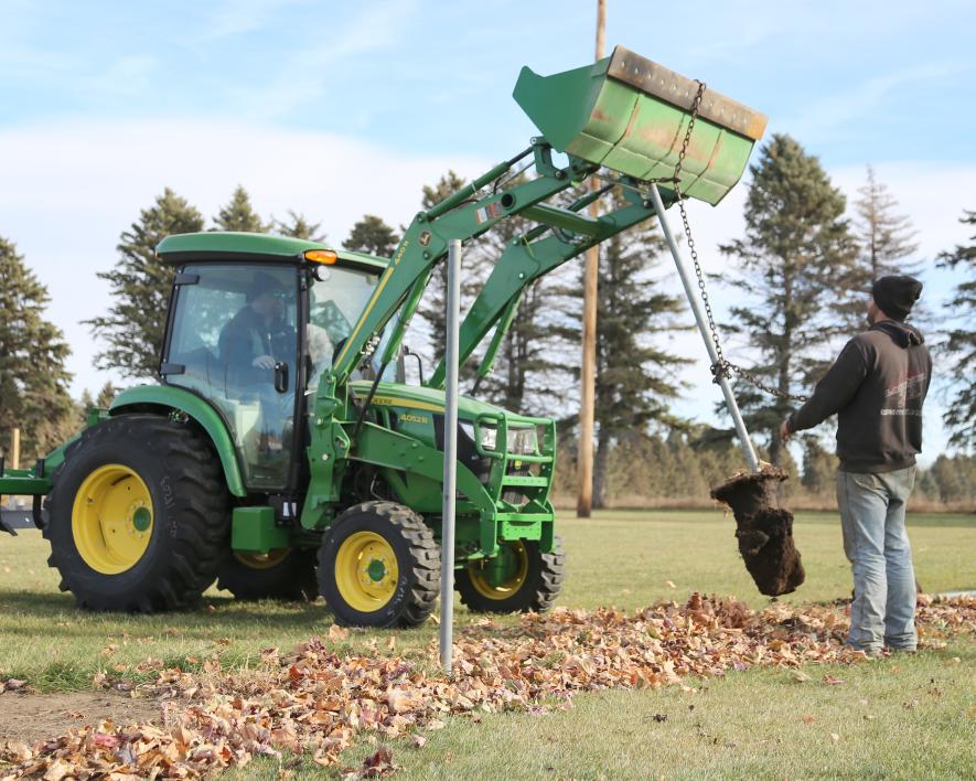 Luverne C&B Operations employees helped remove fence and posts at Joe Roberts Field Wednesday, Nov. 22, as part of their community impact program. Evan Witty, bucket operator, and Keith Vockrodt lift posts after the fence was removed.