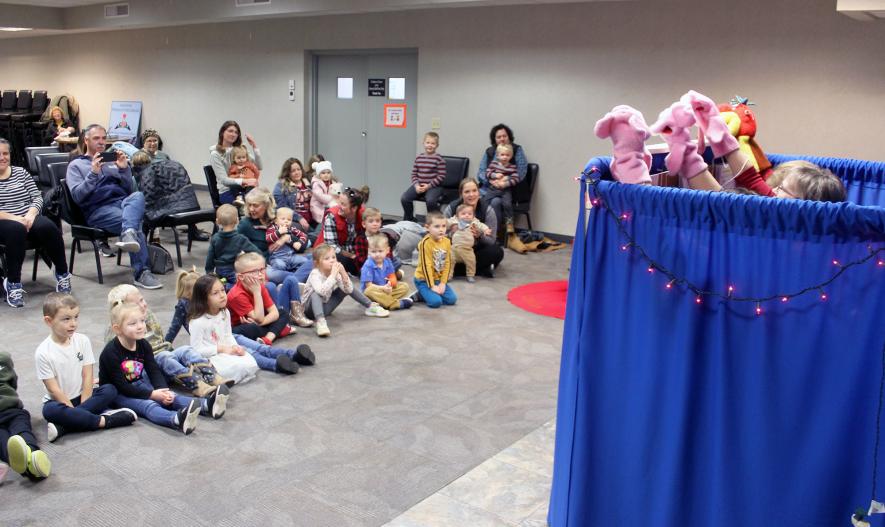 Visitors to the Rock County Library’s puppet show, “Christmas-itis,” watch as the story of various visitors to the library unfolds. The puppets came to life by (behind the curtain) Glenda Bremer, Barb Verhey and Bronwyn Wenzel Friday morning. Opening the show were (from left) the three pigs, Leonard, Louis and Lumpy, and Librarian Mrs. Butler. Mavis Fodness/Rock County Star Herald Photo
