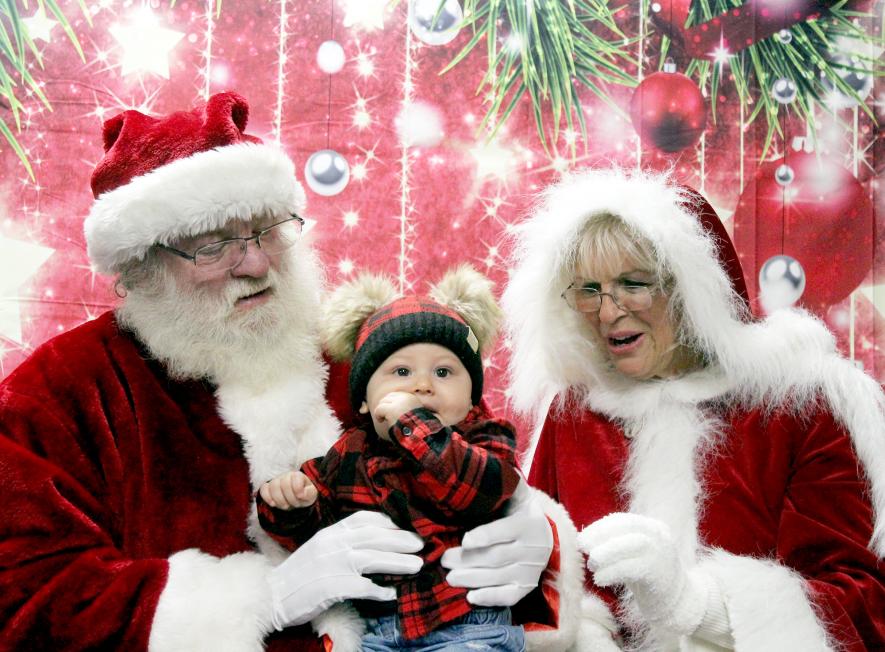 Jasiah Natte (center) looks to the camera as Santa and Mrs. Claus get ready for the taking of a Christmas picture. Mavis Fodness/Rock County Star Herald Photo