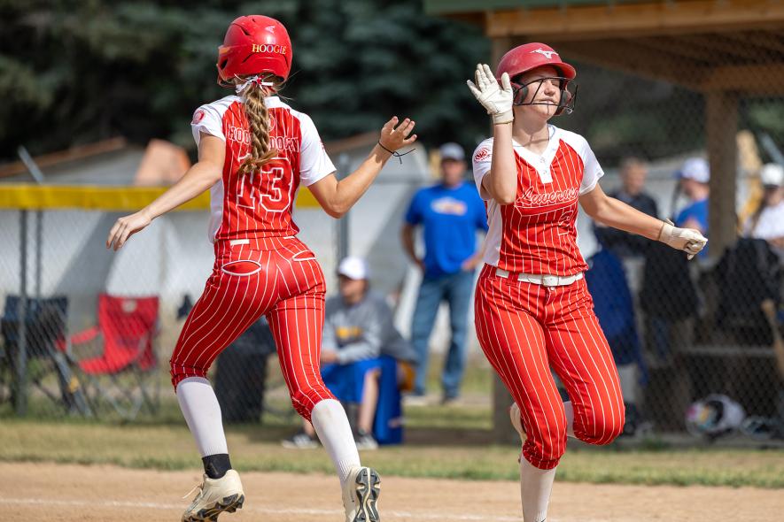 12U players Molly Hoogendoorn,  No. 13, and Avery Van’t Hof slap hands switching spots on the field June 26.