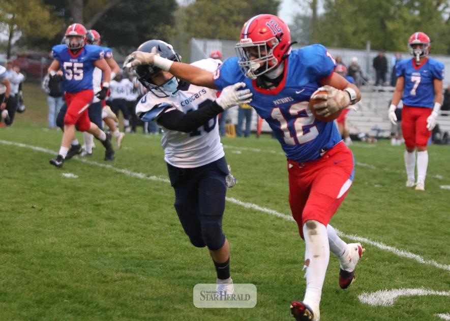Rock CountyH-BC wide receiver EJ Wegener pushes off a Cougar defender as he rumbles downfield for a first down.  Star Herald Photo
