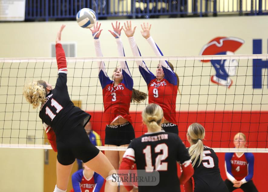 Sophomores Olivia Deelstra, No. 3, and Ava Steinhoff, No. 9, extend to block an Edgerton spiker above the net. H-BC fell 3-2 to the Flying Dutchmen Friday at home.