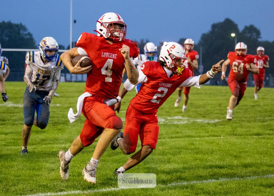 Greg Hoogeveen photo/0924LHSFB1 LHS senior Ben Hartquist runs along the sideline on his way to the end zone flanked by senior Jaymyn McLaughlin Friday, Sept. 18, in Luverne. LHS beat Windom 47-3 in the game.