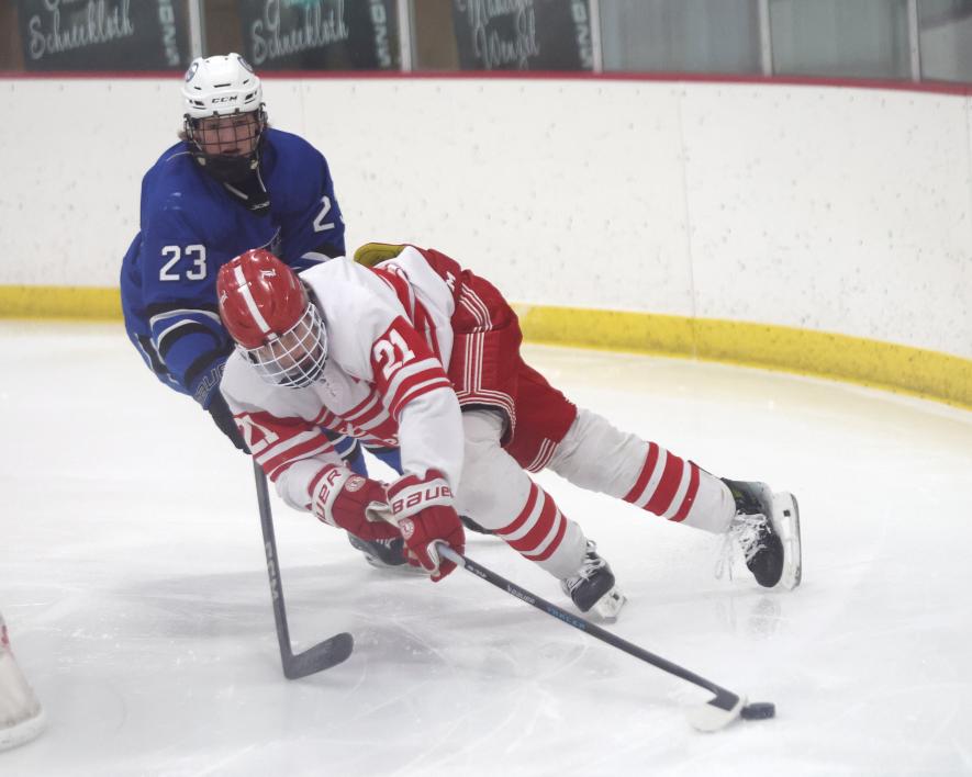 LHS junior forward Maddux Domagala finesses the puck behind the Minnesota River goalie with a defender in tow. The game ended in a 3-3 tie in Luverne after one overtime period. Greg Hoogeveen/Rock County Star Herald Photo