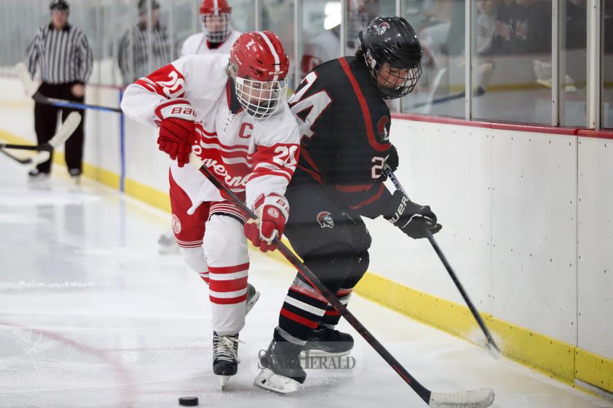 Senior Marcus Vortherms fights a Worthington player for the puck along the boards in Luverne Dec. 10. The LHS boys’ hockey team defeated Worthington 13-1 in the game.