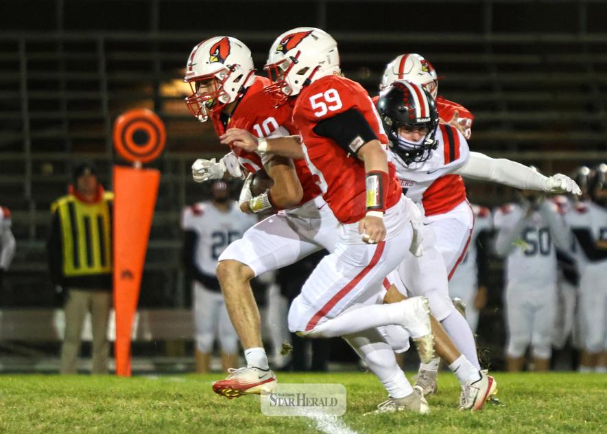 LHS junior Coy Thone, No. 10, carries the ball alongside senior Zeke Frahm as they pass a Belle Plaine defender Oct. 21 in Luverne. The Cardinals beat the Tigers 21-14 in the Section 3AAA quarterfinal matchup.  Greg Hoogeveen photo/LHSFB0