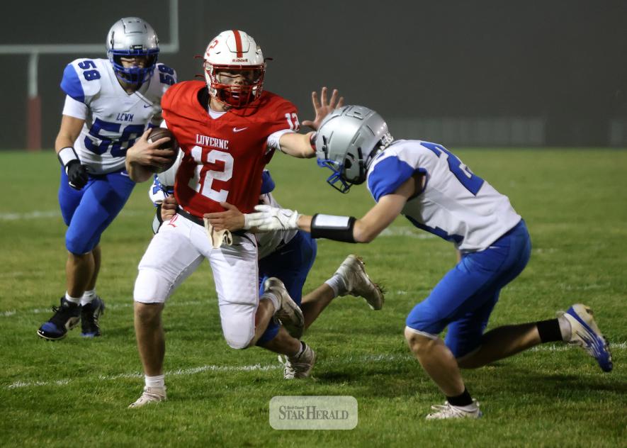 Cardinal quarterback Josh Hansen stiff-arms a Lake Crystal defender on his way to the sideline. 