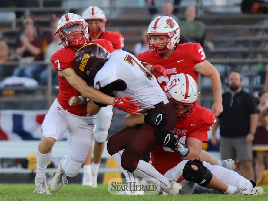 Junior Connor Bose, No. 7, wraps his arms around the Bucs running back as senior Eli Woodley, No. 51, grabs the midsection on a tackle Friday, Sept. 27, at home.  LHS won the game 48-14.