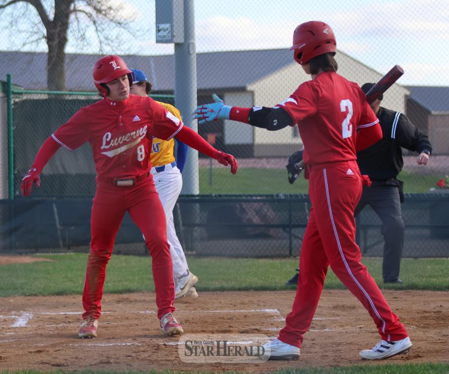 Sophomore Landyn Lais (left) and senior Jacob Stroh celebrate after Lais slid into home plate safe against Windom Thursday, April 18, at Redbird Field. Luverne beat the Windom Eagles 11-7.