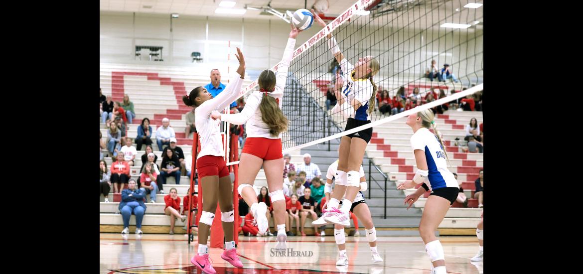 Greg Hoogeveen photo/LHSAE1 LHS sophomore Emma Cowell jumps to lift the ball as A-E sophomore Charlee Hehnhoff follows through with a spike attempt above the net Thursday, Oct. 22, in Luverne. The Dragons beat LHS 3-0 in the Cardinals final match of the regular season.