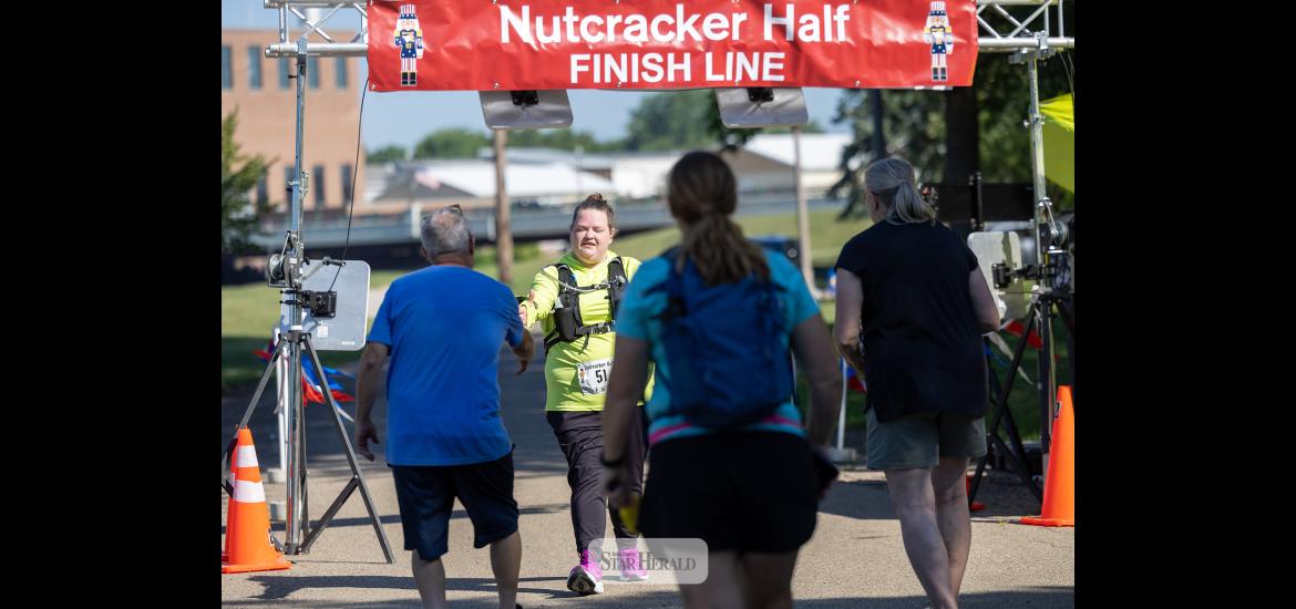 Greg Hoogeveen photo/NCmarathon Shelby Bell of Topeka, Kan., is greeted by Dave Duffy and volunteers after she finished the Nutcracker Half Marathon Walk Saturday, July 11, in Luverne. 