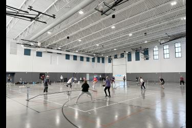 Five mornings a week, dozens of pickleball players gather in the National Guard Readiness Center assembly hall, which is divided into three courts to accommodate simultaneous games. Lori Sorenson/Rock County Star Herald Photo