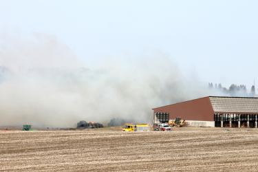 Fire departments from Luverne, Hills, Hardwick and Beaver Creek help contain fire to about 500 hay and cornstalk bales Saturday afternoon, April 6, at a farm west of Luverne. Southeast winds up to 55 mph pushed the fire into a nearby grass waterway and cornfield. Mavis Fodness/Rock County Star Herald Photo
