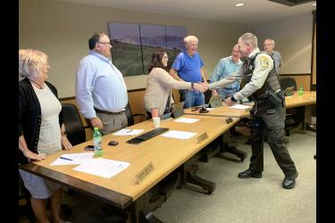 Derek Werner (far right) shares a laugh as he shakes the hands of commissioners (from right) Stan Williamson, Greg Burger, Gary Overgaard and Sherri Thompson along with county administrator Kyle Oldre and assistant administrator Susan Skattum. Mavis Fodness/Rock County Star Herald Photo