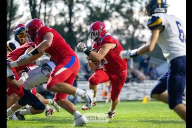 Greg Hoogeveen photo/0917HBCFB1 Patriots senior Riggins Rheault, No. 5, follows blockers to the end zone against Renville County West Friday, Sept. 11, at home. H-BC won the shortened game 38-6.  