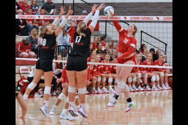 Senior Morgan Ahrendt spikes the ball through two Worthington middle blockers in Luverne. The Cardinals beat the Worthington Trojans 3-2 Tuesday, Sept. 26.