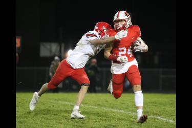 Senior Gavin DeBeer braces for impact running the ball against Redwood Valley Wednesday, Oct. 18, in Luverne. The Cardinals won the final regular season game 33-21.