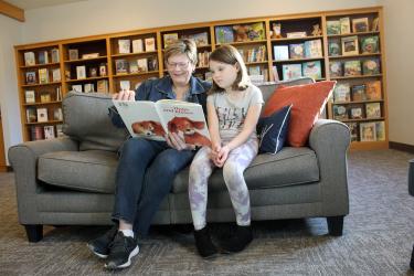 Retired elementary teacher Sandy Klosterbuer (left) reads with second-grader Claire Bierman in the remodeled library at Grace Lutheran Church, Luverne. Klosterbuer, along with three other educators, developed Grace Reading Buddies, where volunteers read with elementary-aged children two afternoons a week. Mavis Fodness/Rock County Star Herald Photo