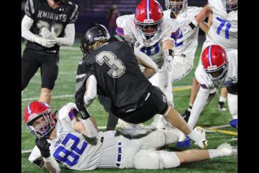 Patriots senior Riley Tatge (No. 82) and teammates bring down a Kingsland runner Thursday, Nov. 9, in 9-player state quarterfinal action. The Knights beat H-BC 26-14 to move on to the state action.